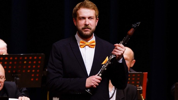 Высокий блондин с кларнетом и оркестром