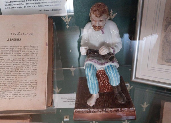 История экспоната «Фарфоровая статуэтка «Крестьянин чинит валенок»